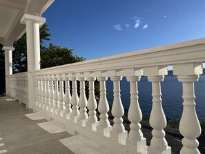 Une balustrade blanche ornée de colonnes, donnant sur une étendue d’eau.