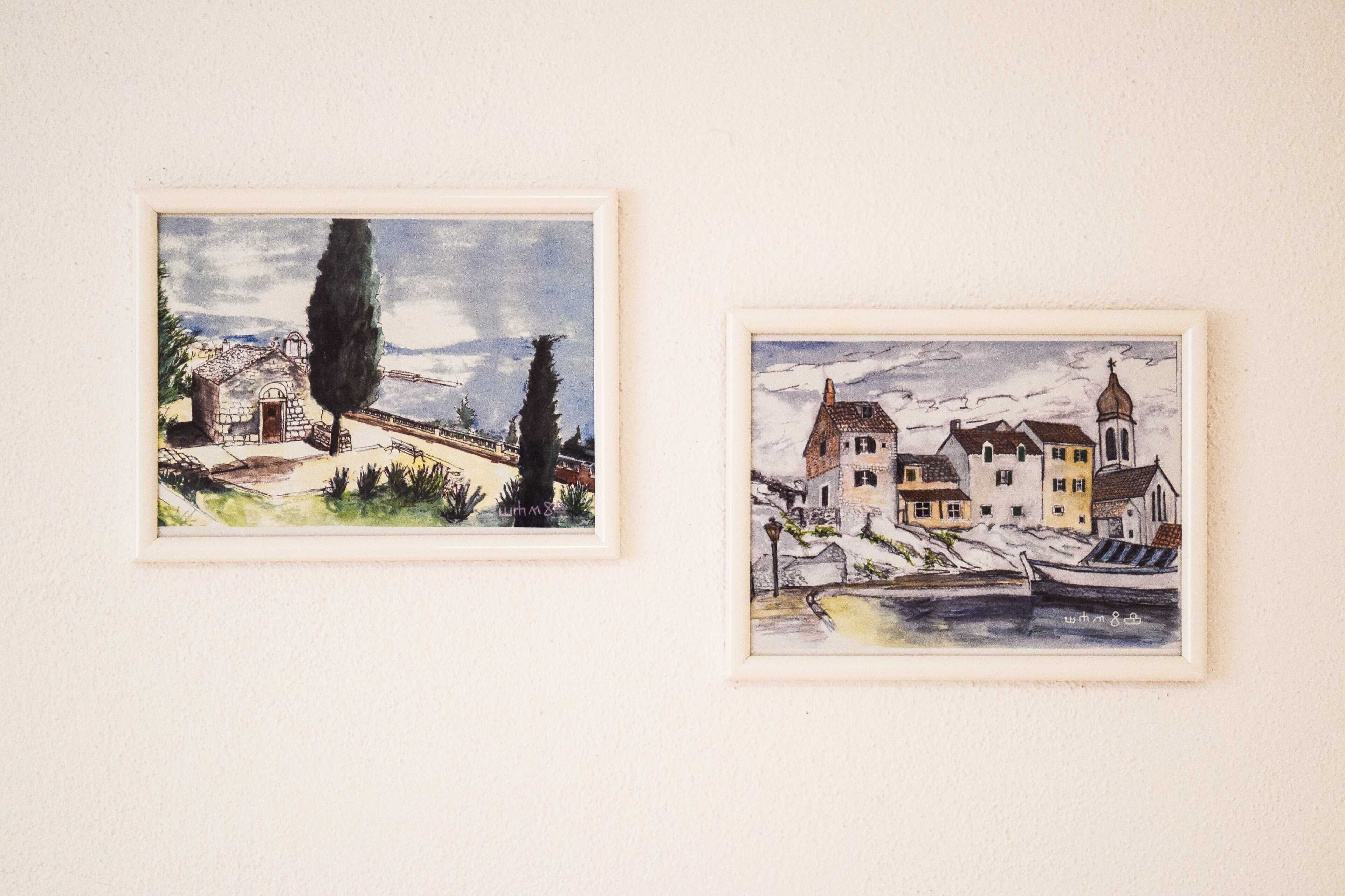 Two framed watercolor paintings of landscapes.