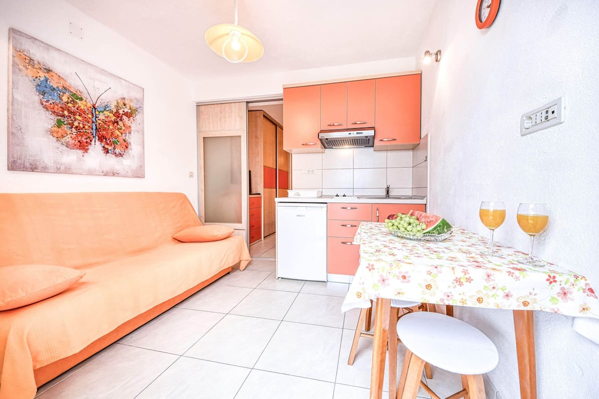 A compact living space with a sofa, dining table, and kitchenette.
