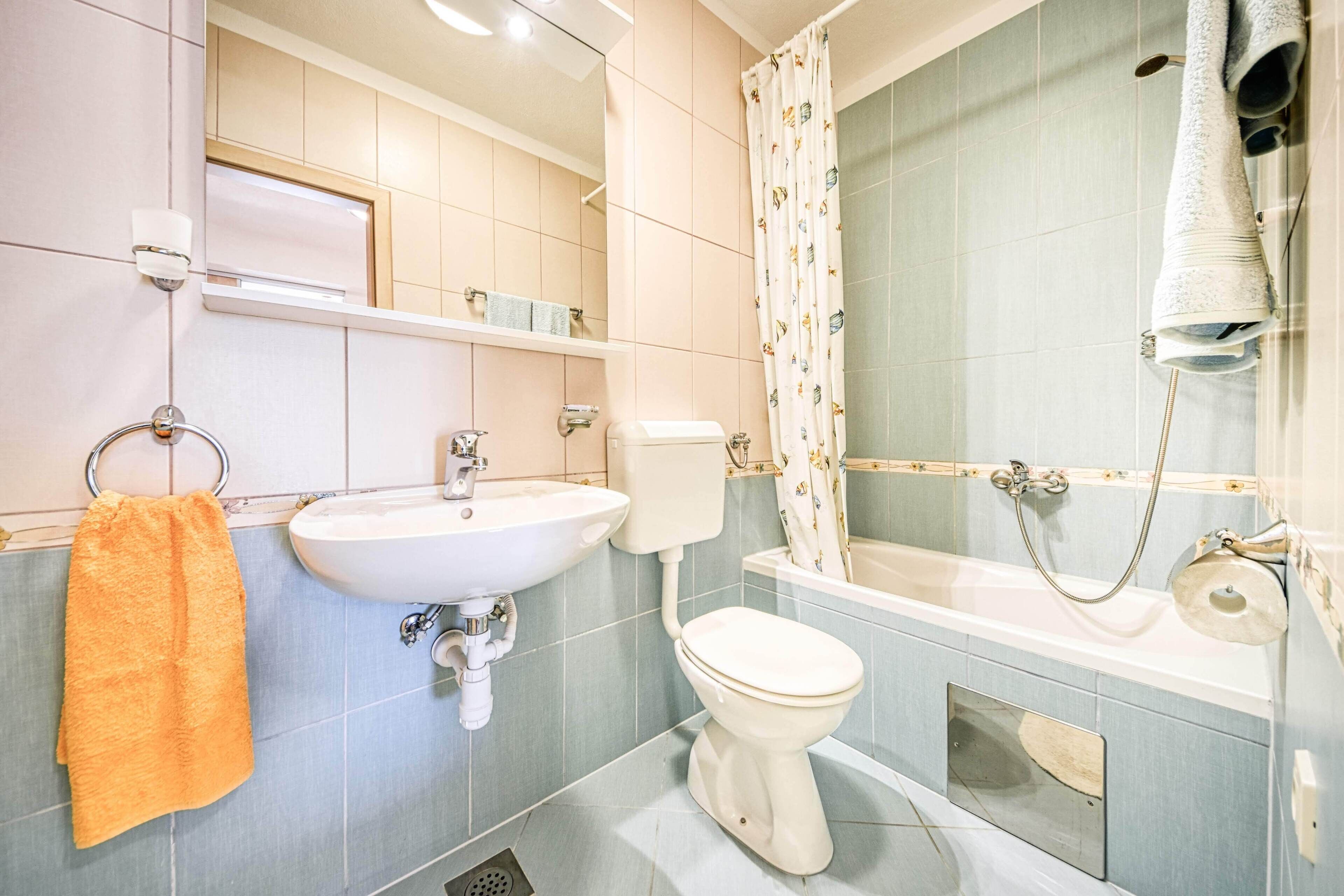 A bathroom with a sink, toilet, and bathtub.