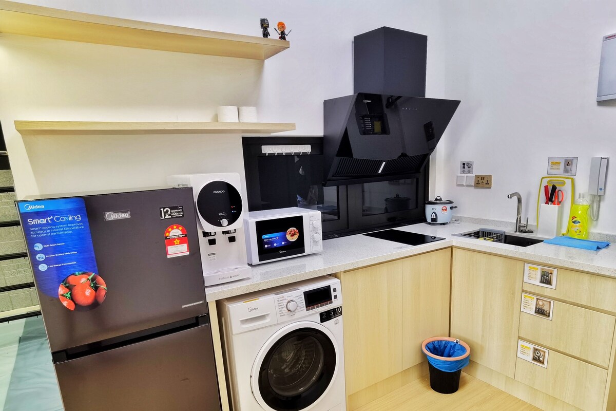 A compact kitchen with a microwave, coffee maker, and washing machine.