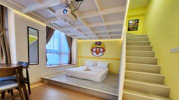 A bedroom with a bed, a desk, a projector, and a staircase.