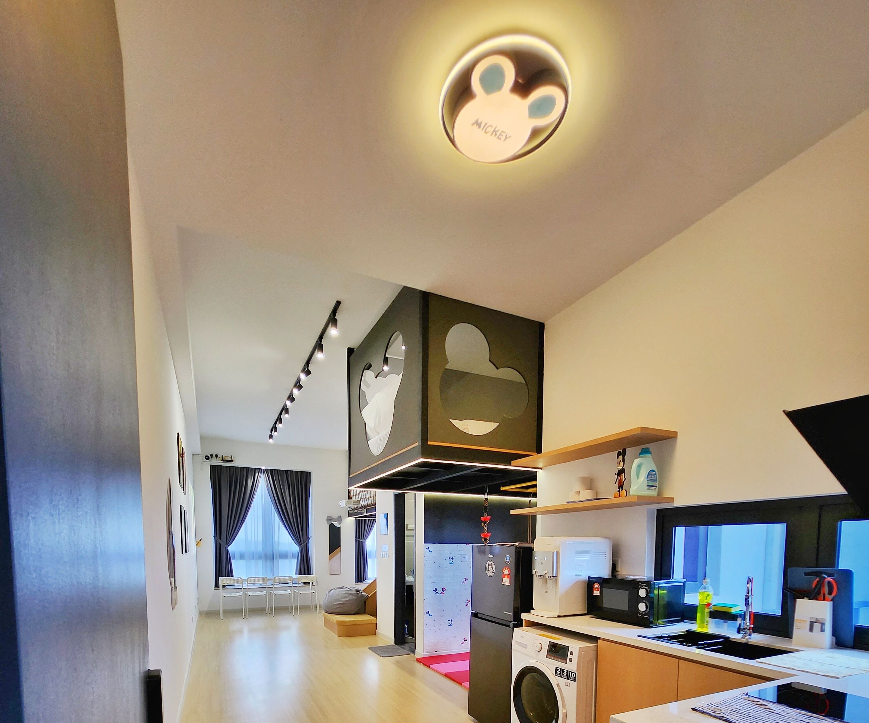 Een moderne keuken met een wasmachine, magnetron en koelkast.