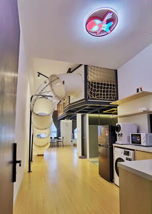 A modern kitchen with a built-in refrigerator, microwave, and coffee machine.