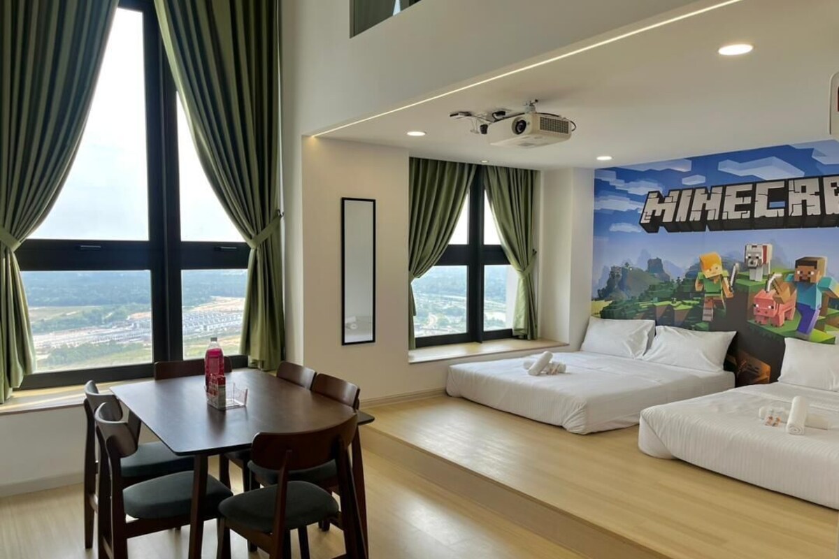 A hotel room with a dining table, two beds, a projector, and a Minecraft-themed wall mural.
