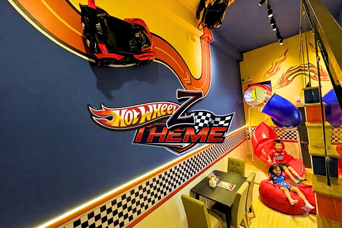 A children's play area with a Hot Wheels theme, including a checkered pattern wall and a racing car decoration.