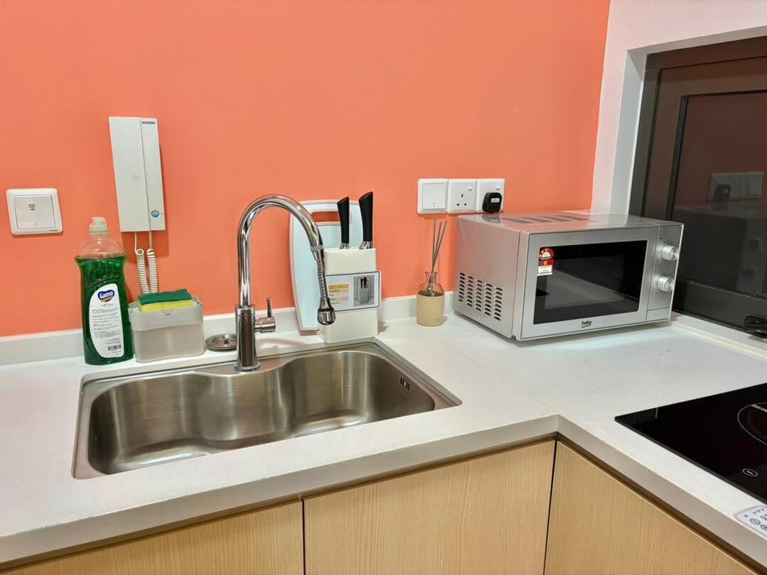 A kitchen with a stainless steel sink, a microwave, and a toaster.