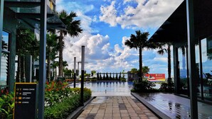 A pathway leading to a swimming pool with a fitness center and lounge nearby.
