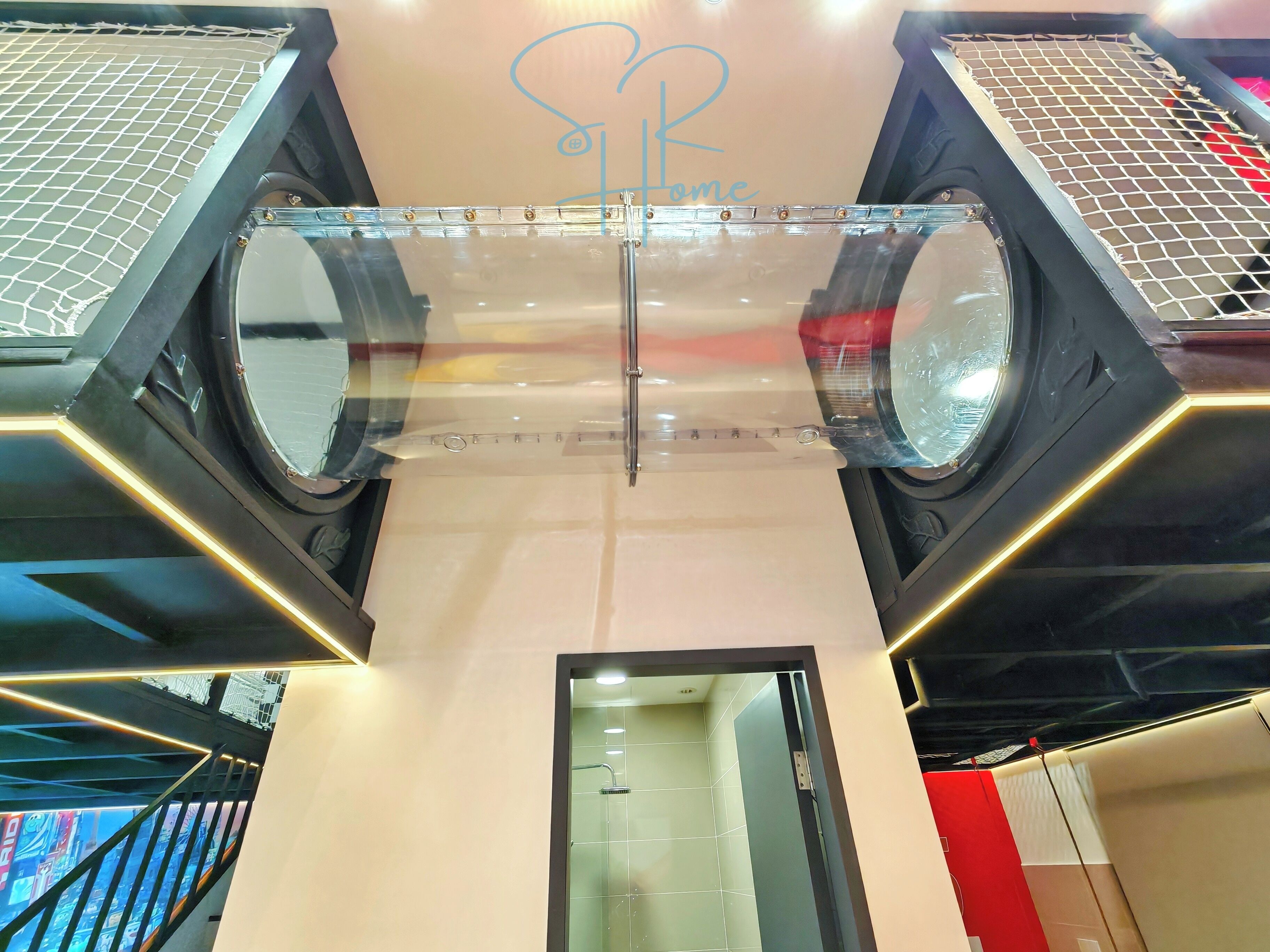 A modern interior with a glass ceiling, a visible elevator, and a sign with a heart symbol.