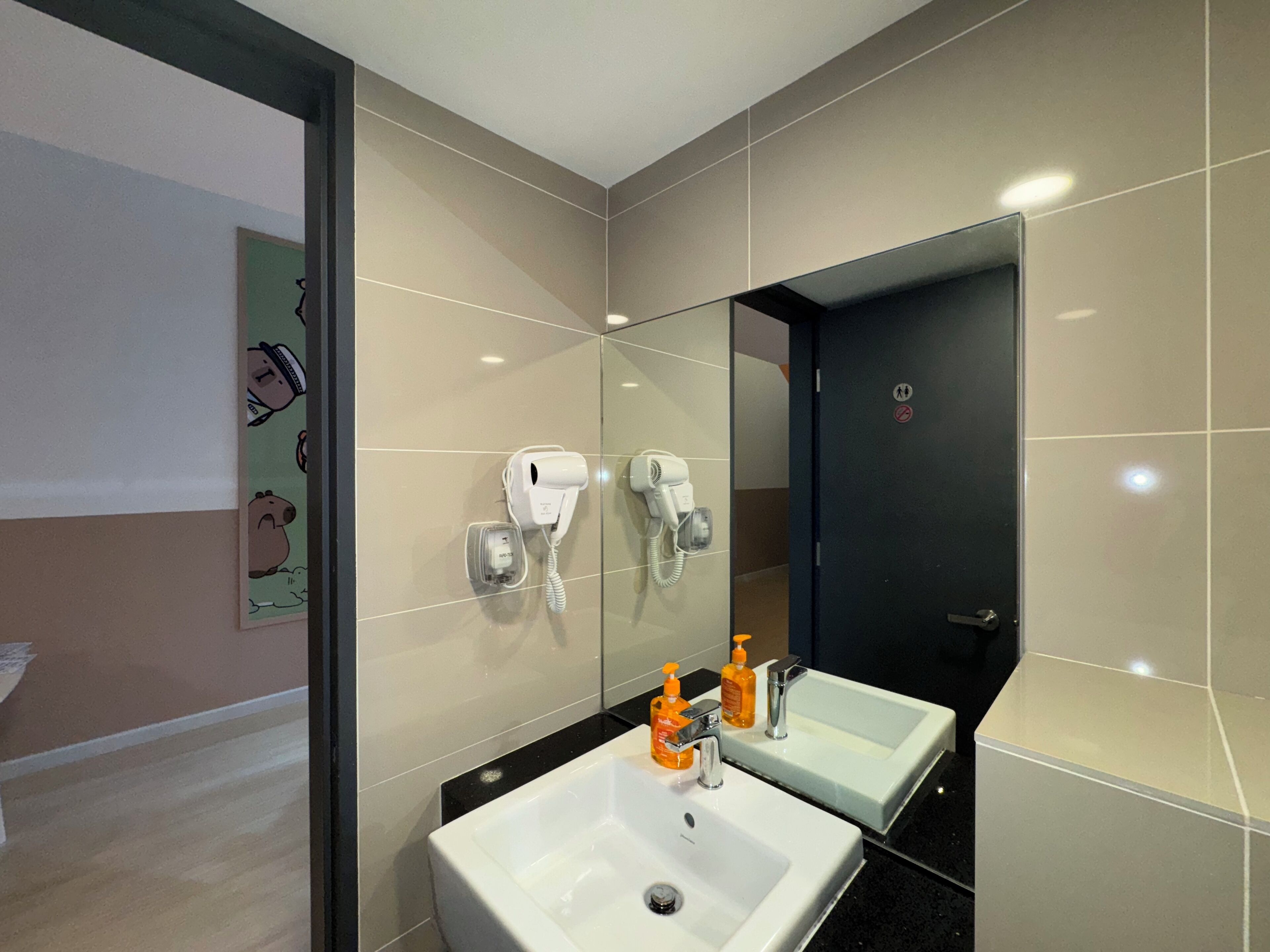 Un bagno moderno con due lavabi, uno specchio e un asciugacapelli.