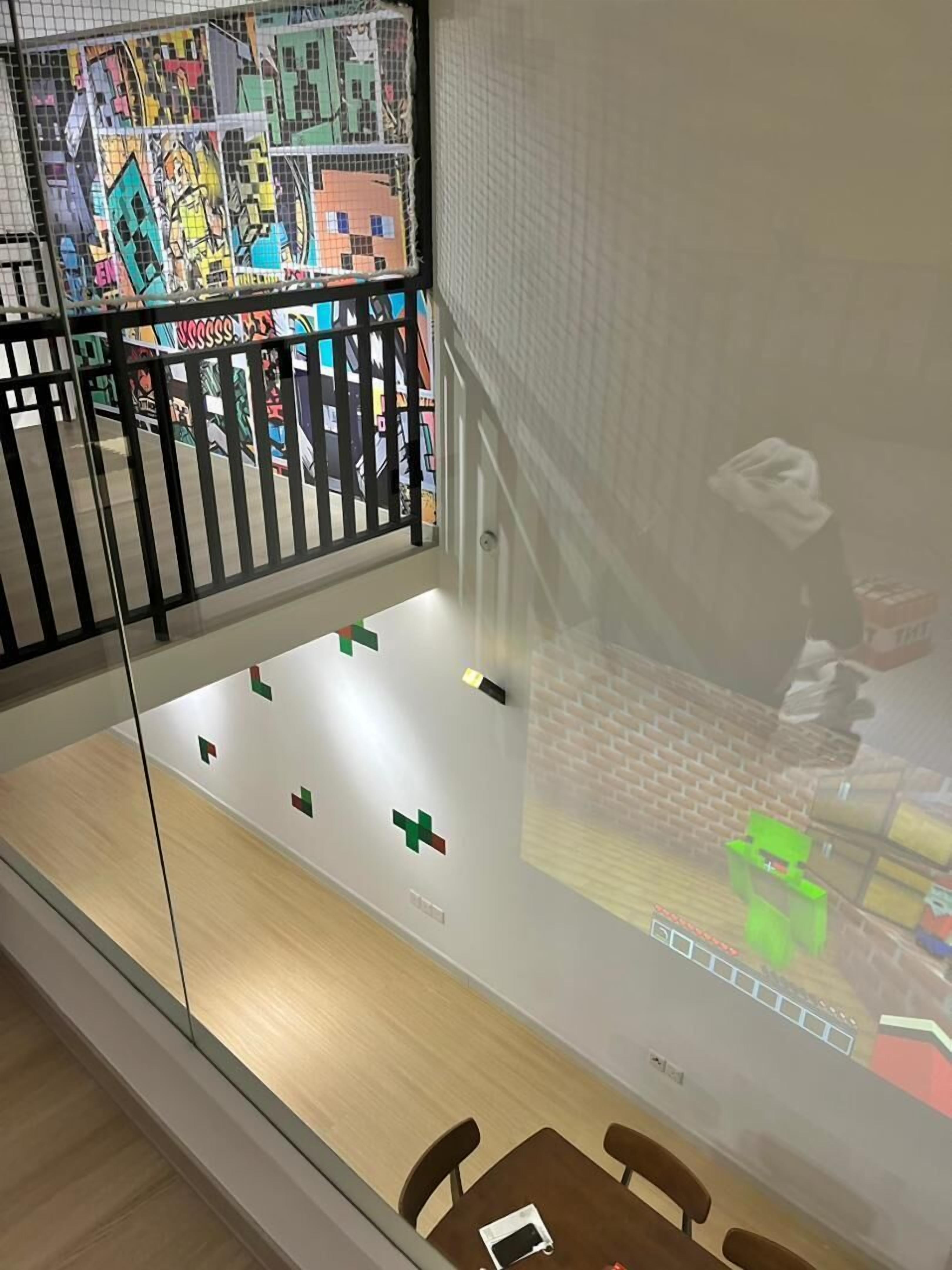 A modern interior with a glass partition, a wooden floor, and a brick wall.