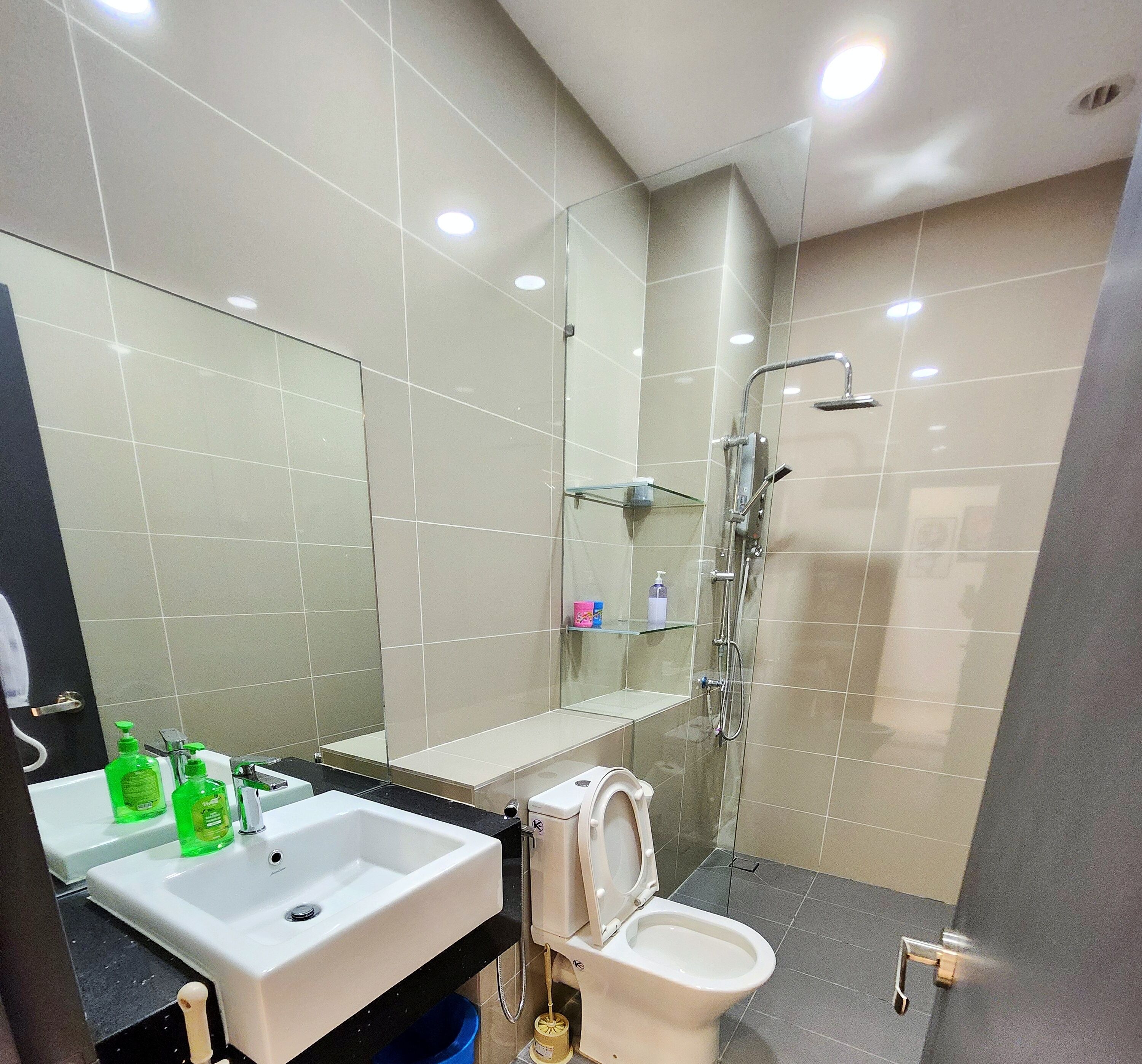 Une salle de bain moderne avec un lavabo, des toilettes et une douche, le tout de couleur blanche.