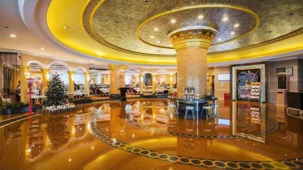 A luxurious lobby with a polished floor, a central column, and a Christmas tree. - Suning Universal Hotel All-Suites (Nanjing)