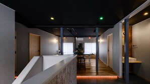 Un moderno vestíbulo de hotel con una recepción, una escalera y un comedor.