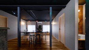 Una cocina moderna con una isla central, taburetes de bar y una mesa de comedor.