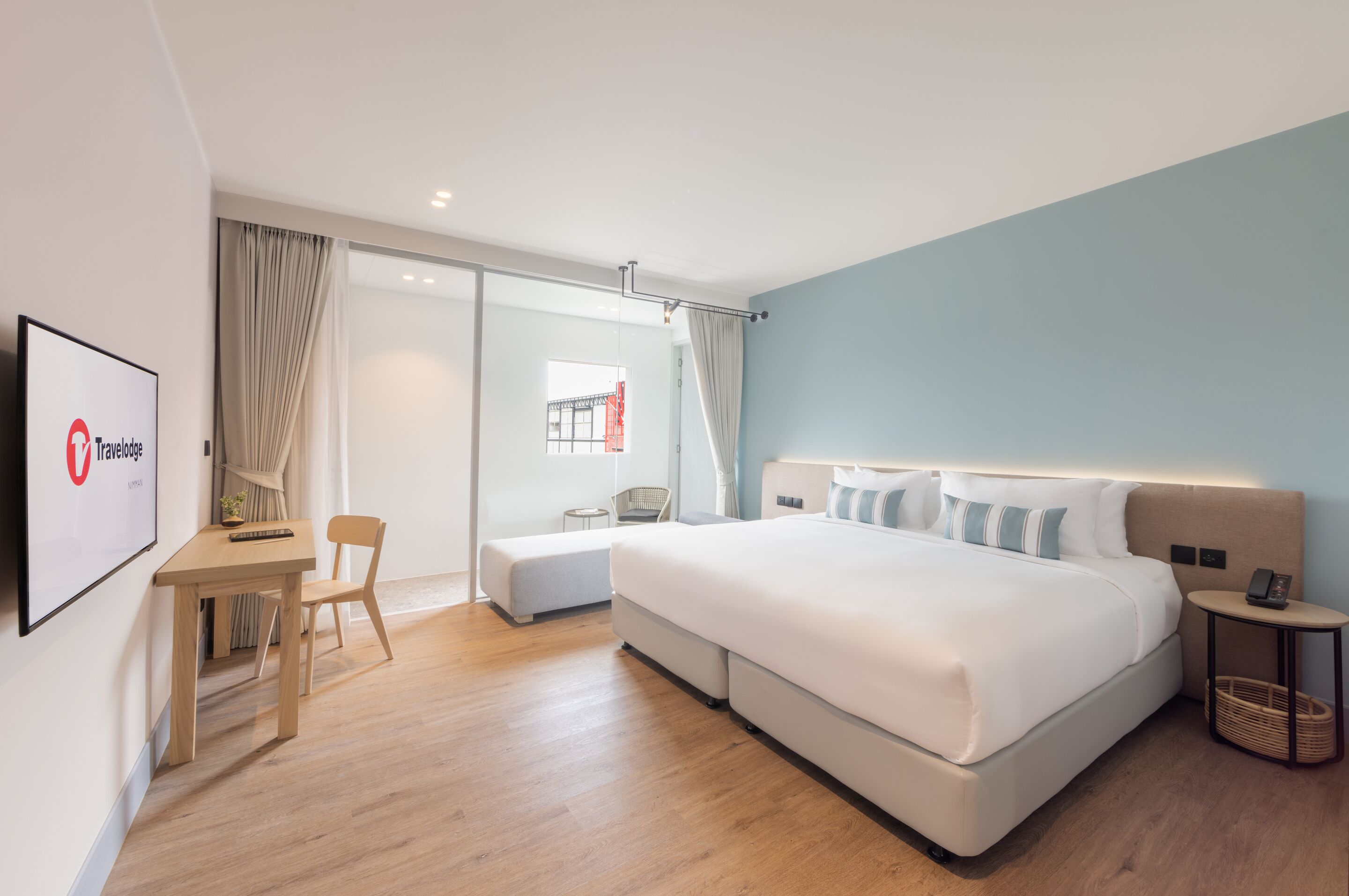Una habitación de hotel moderna con una cama grande, un escritorio y una silla.