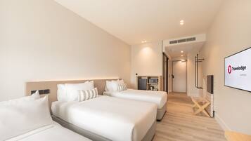 Une chambre d’hôtel avec deux lits, une télévision et un minibar.