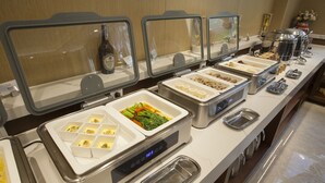 A buffet with various food items and a bottle of wine. - JOY FALL HOTEL (Qingdao)