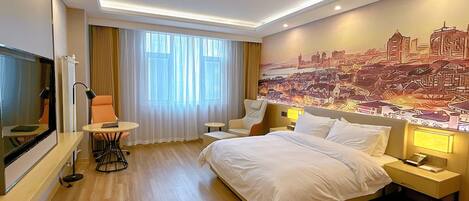 Habitación de hotel con cama, escritorio, silla, televisor y un mural con vistas a la ciudad.