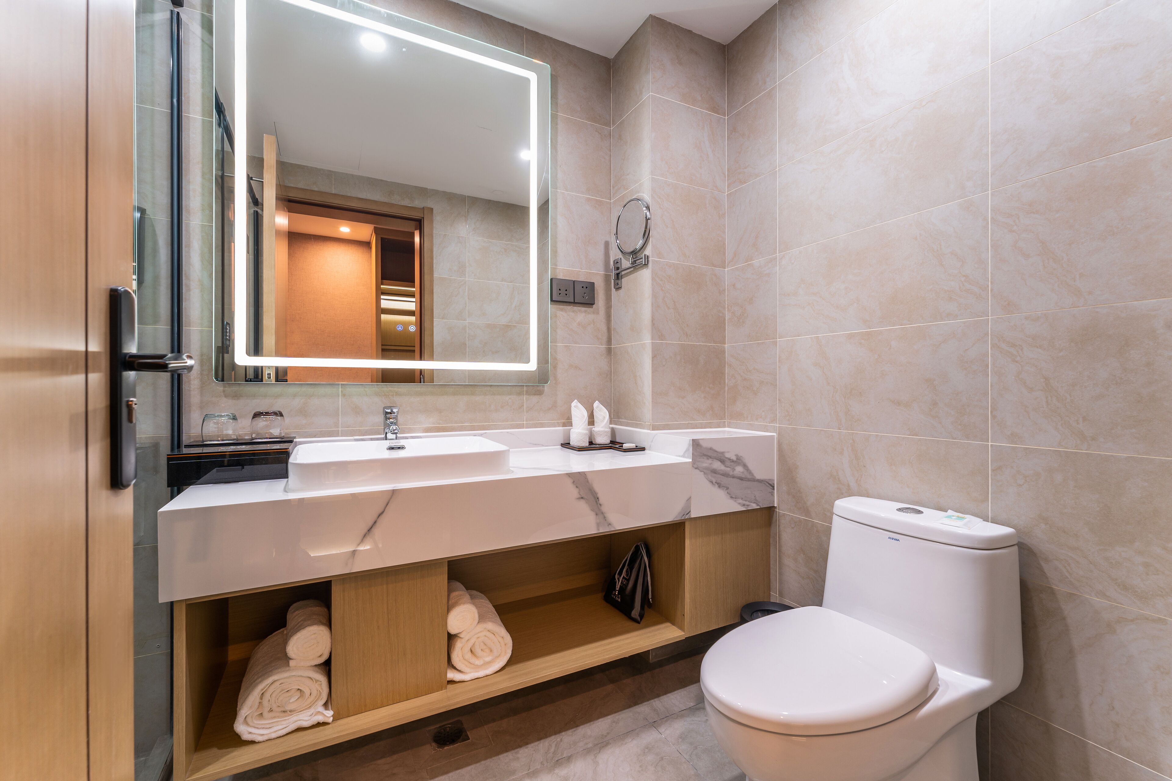 A modern bathroom with a white sink, mirror, and toilet.