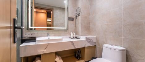 A modern bathroom with a white sink, mirror, and toilet.