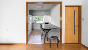 Una cocina compacta con comedor, una puerta de madera y vistas al exterior.