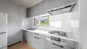 Una cocina moderna con lavavajillas incorporado, estufa a gas y una ventana sobre el fregadero.