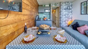 Una sala acogedora con un muro de madera, una mesa de comedor lista para una comida, y un sofá con cojines.