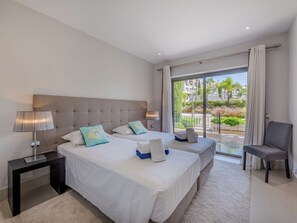A hotel room with two beds, a sitting area, and a balcony with a view. - Pine Hills Ametista by Interhome (Vilamoura)