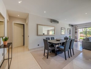 A modern dining area with a large table, chairs, and a mirror on the wall.