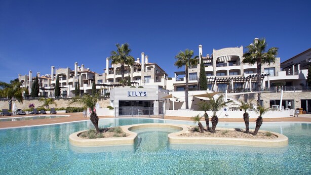 A hotel with a pool area, palm trees, and a sign for 'Lily's'. - Pine Hills Pérola by Interhome (Vilamoura)