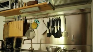 A kitchen with stainless steel appliances, a sink, and hanging utensils. - THE BOZZLE, THE COMBA of Aosta (Valle d'Aosta)