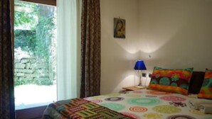 A bedroom with a bed, a nightstand, a lamp, and a window with curtains. - THE BOZZLE, THE COMBA of Aosta (Valle d'Aosta)