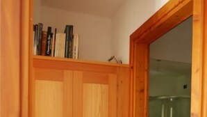 Uma lavanderia com máquina de lavar e porta de madeira com pequena janela.