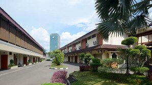 Un hôtel doté d’une cour intérieure, comprenant un bâtiment moderne à toit plat et un bâtiment traditionnel à toit en pente.