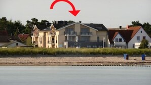 A row of houses by a calm body of water.