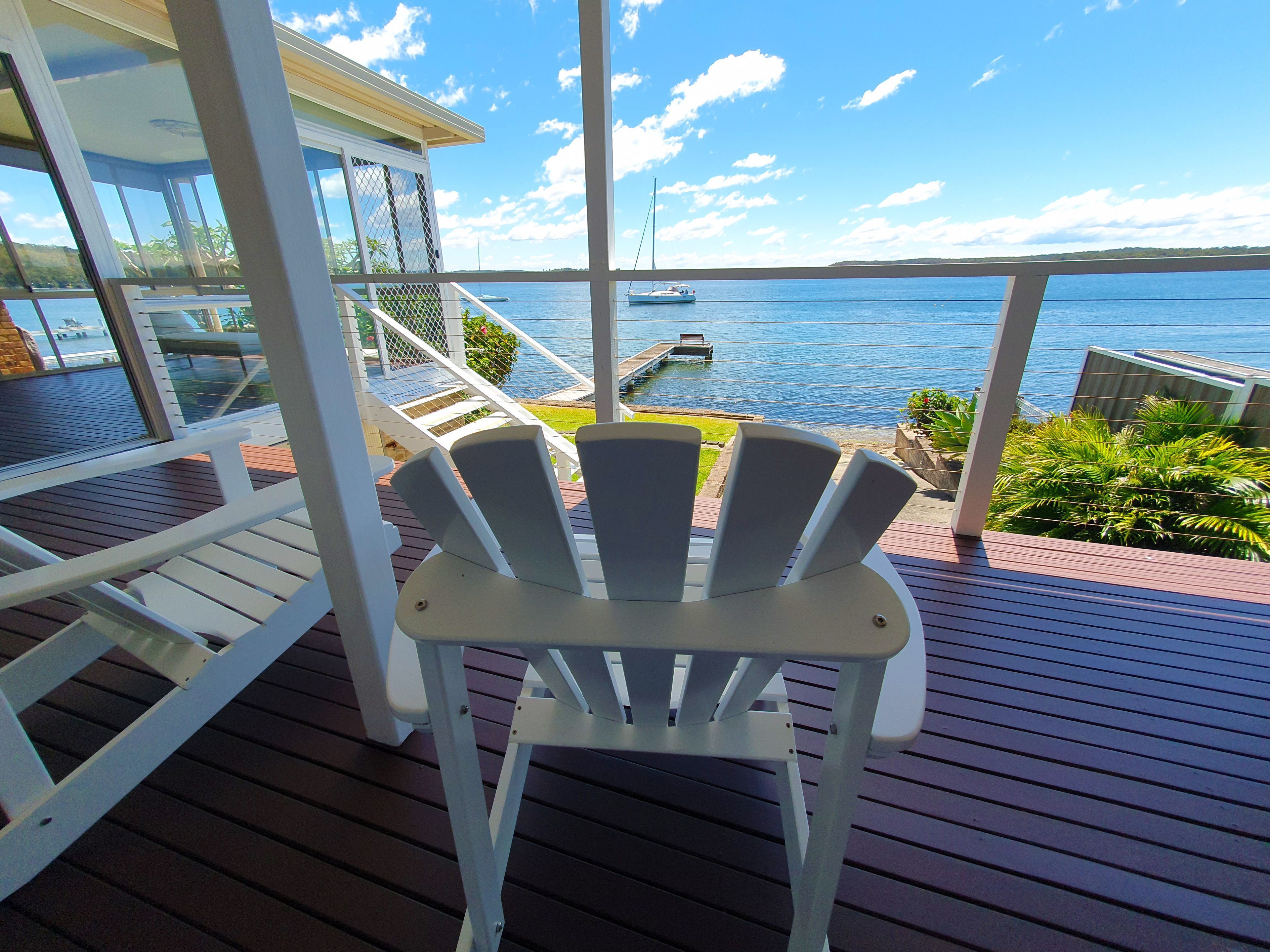 A deck with a chair and a view of the sea.