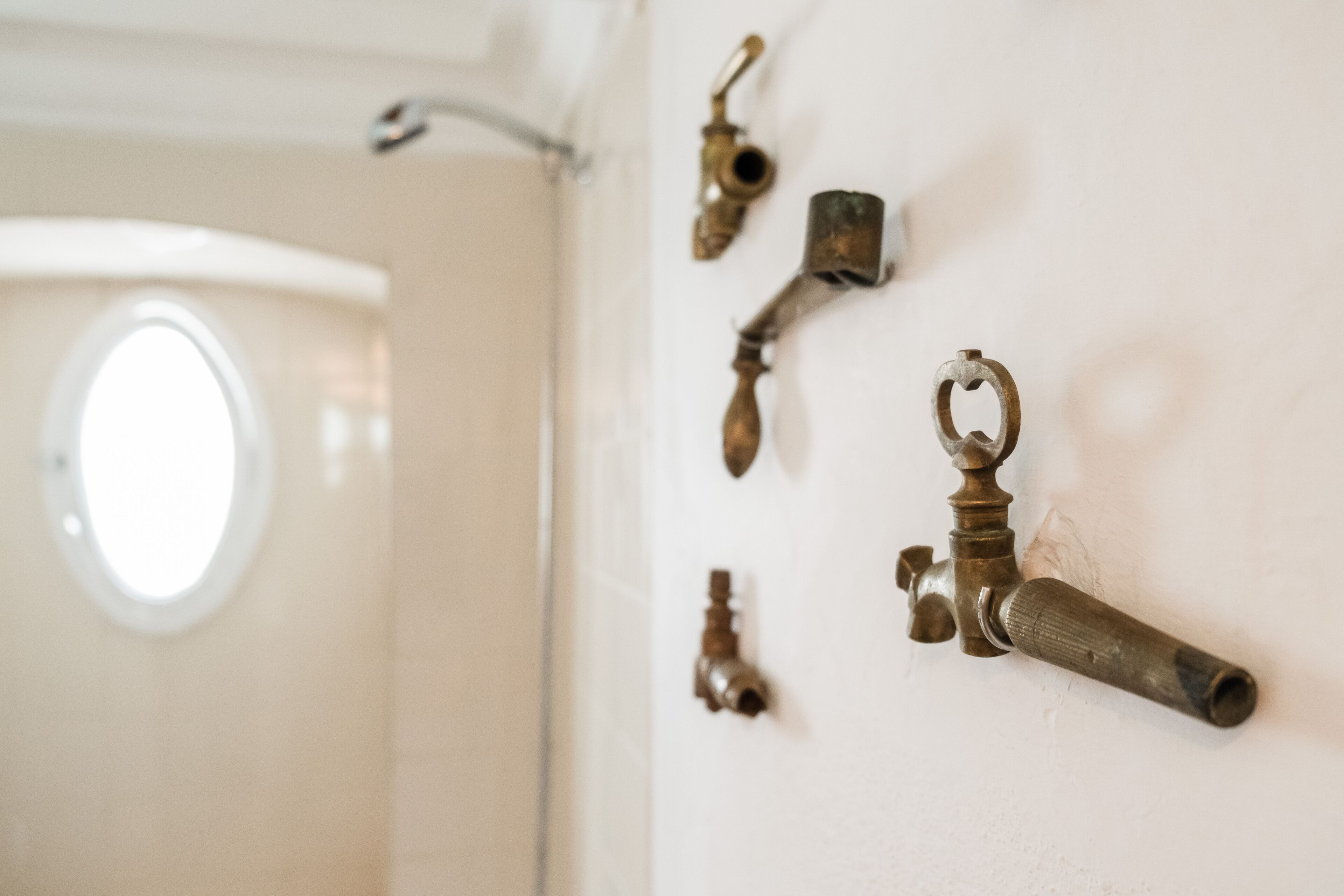 Un baño con una pared blanca y una ventana.