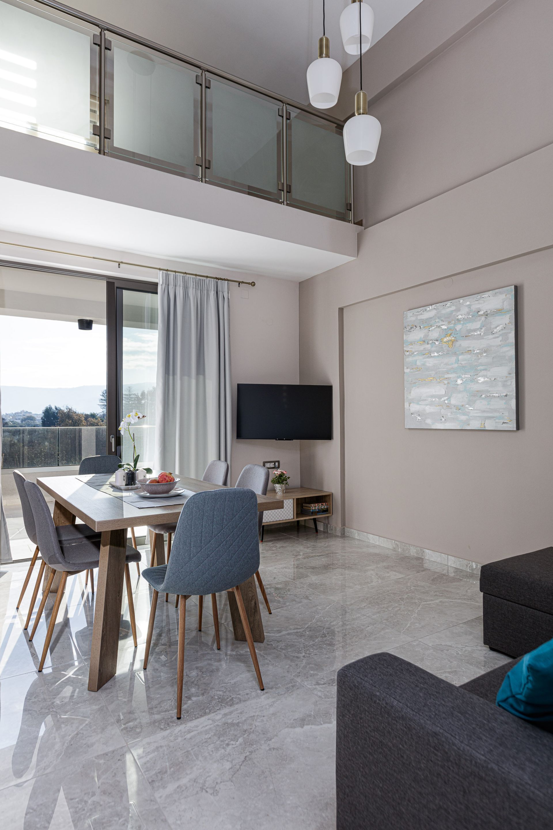 Un salon moderne comprenant un coin repas, un téléviseur à écran plat fixé au mur et un grand tableau abstrait.