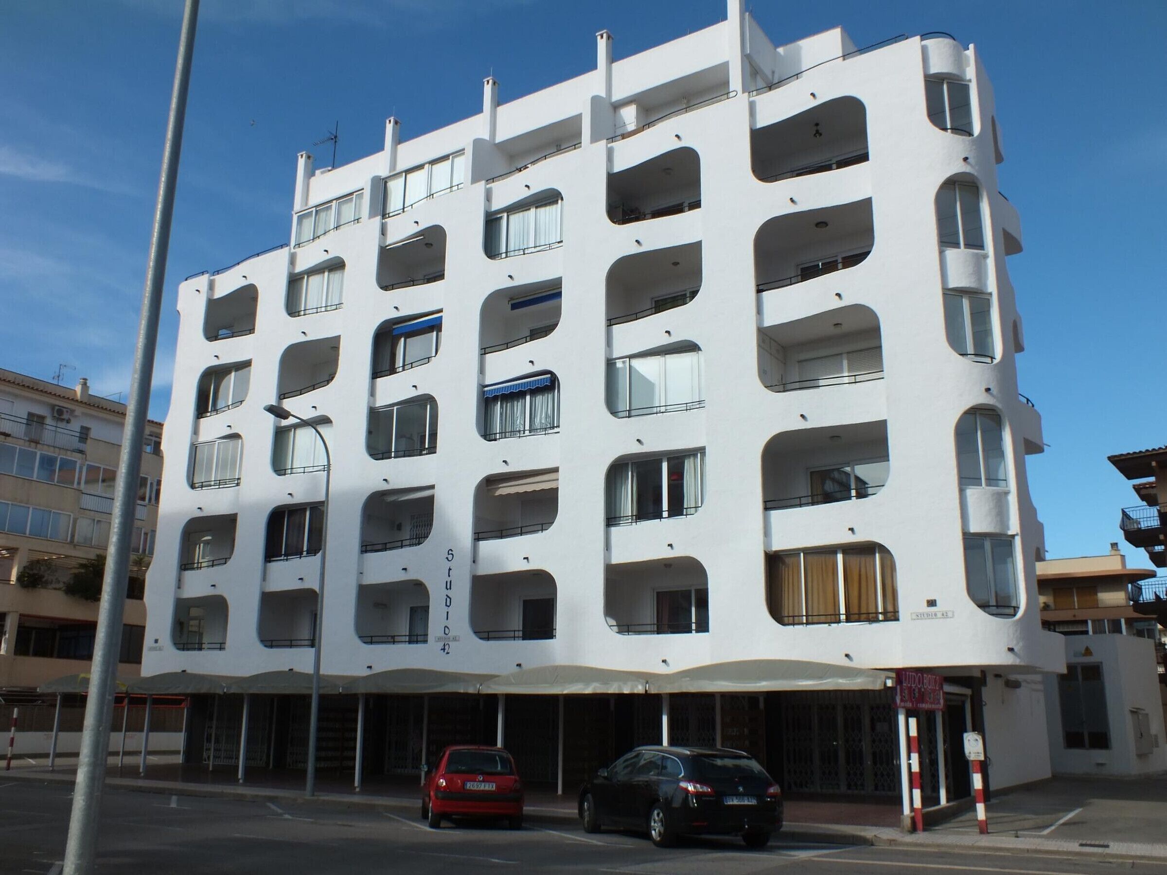 Een meerlaags gebouw met een opvallend architectonisch ontwerp, met ronde balkons en grote ramen.