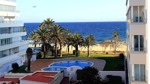 A hotel with a pool, palm trees, and a view of the ocean. - Comfortable apartment, 50m from beach, 4 people, terrace, TV, washing machine (Roses)