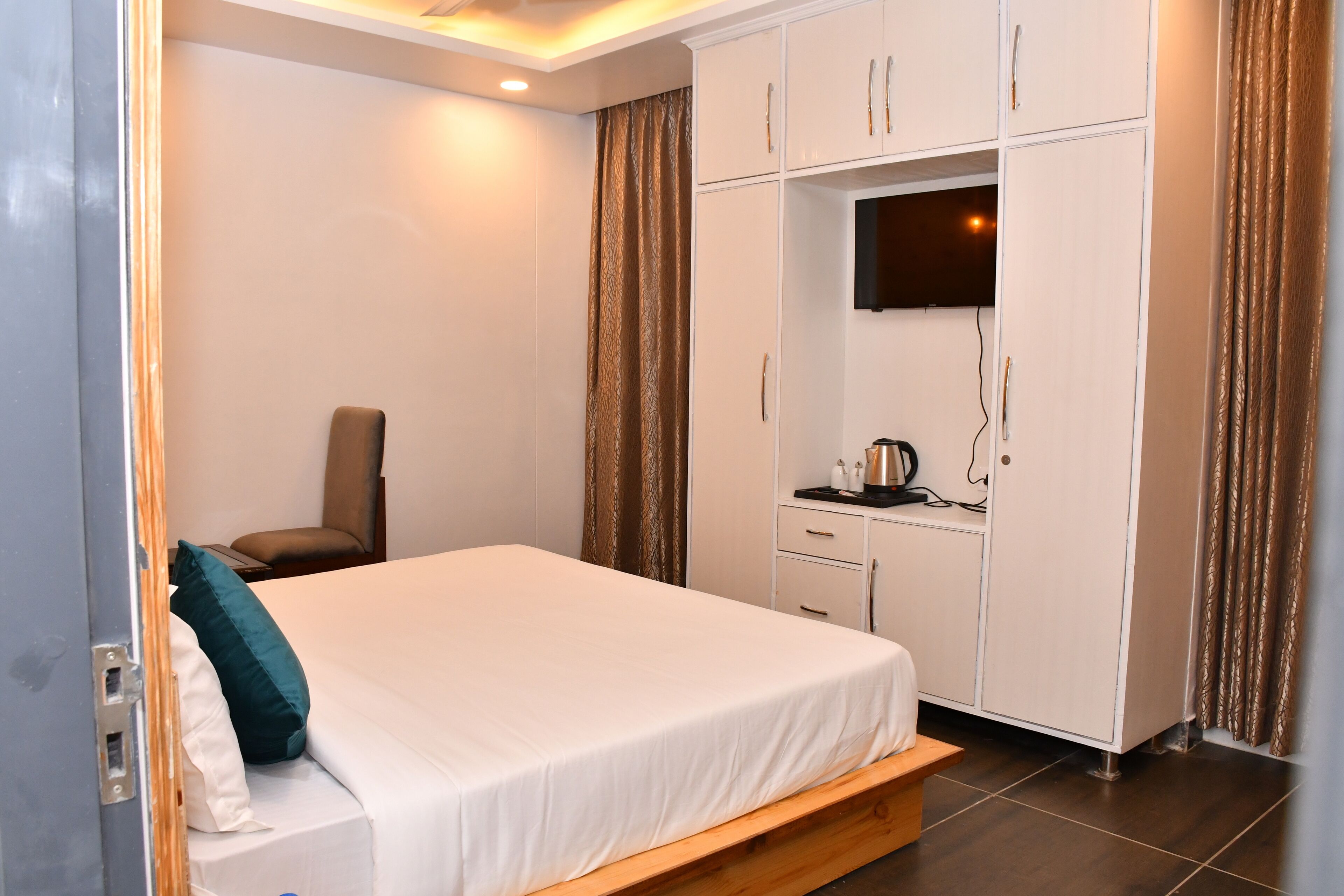 A hotel room with a bed, a desk, and a television.