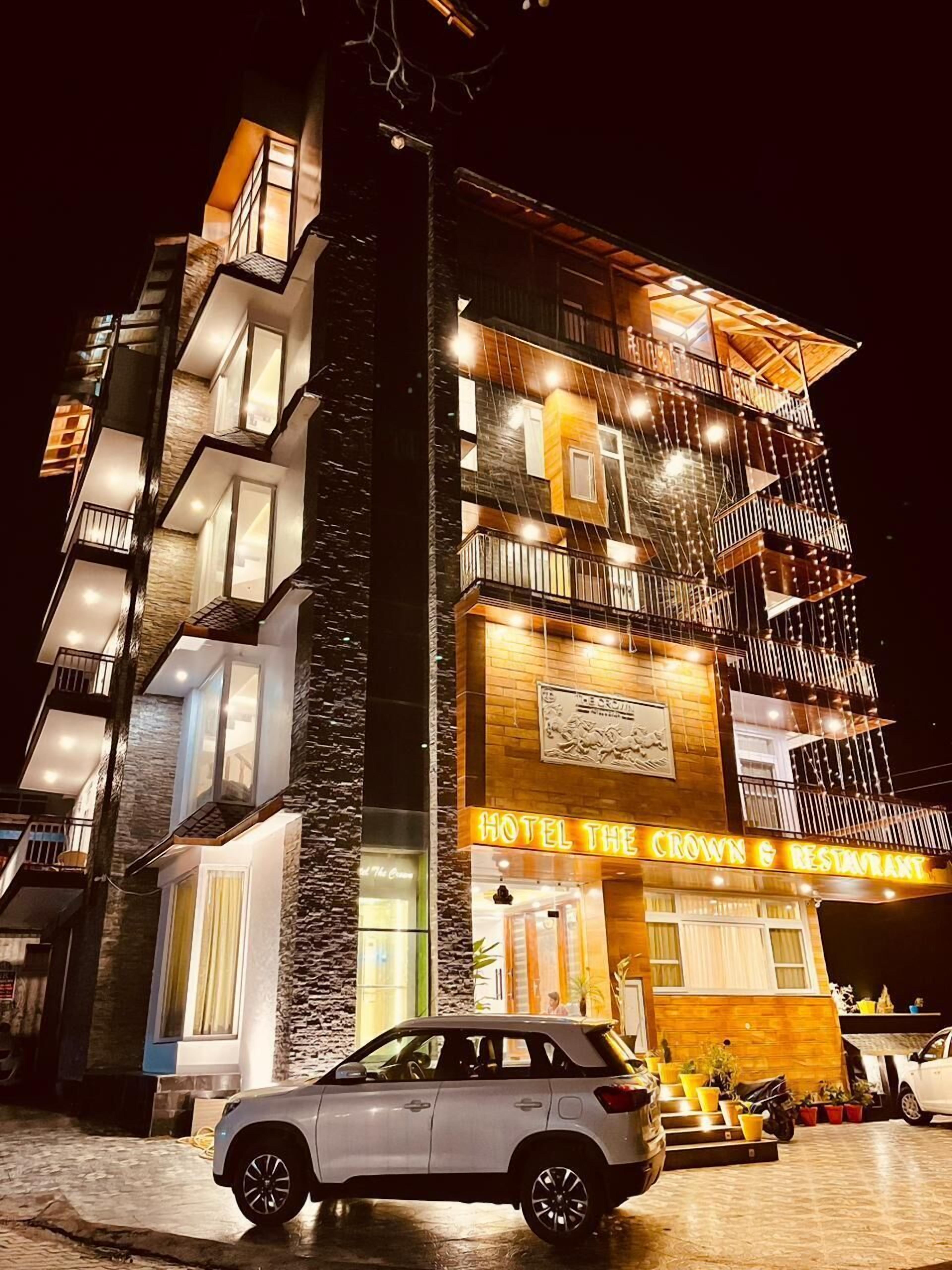 Et hotel med flere etager, med et tydeligt skilt der siger "HOTEL THE CROWN & RESTAURANT".