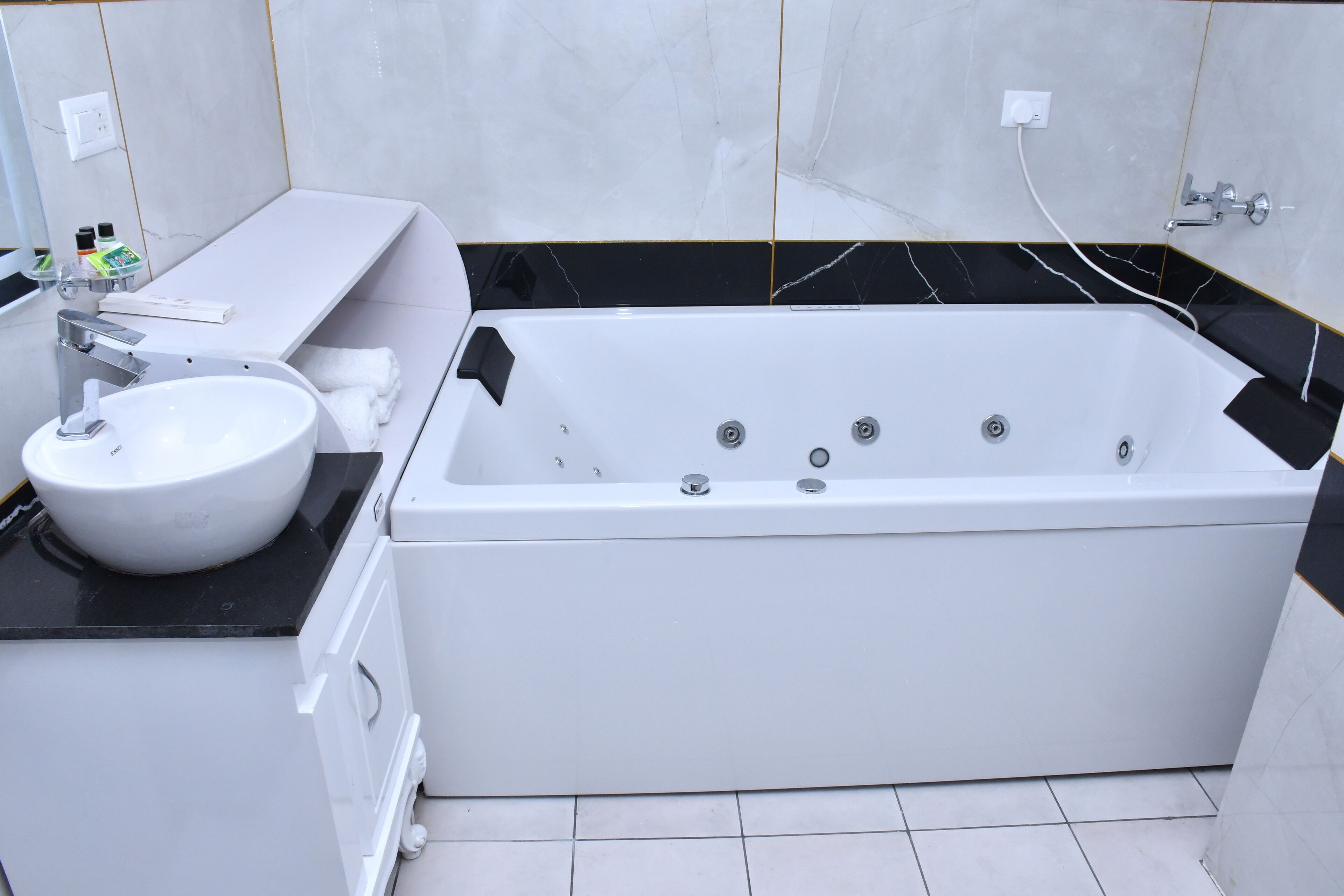 A modern bathroom with a white bathtub, a round sink, and a vanity with a mirror.