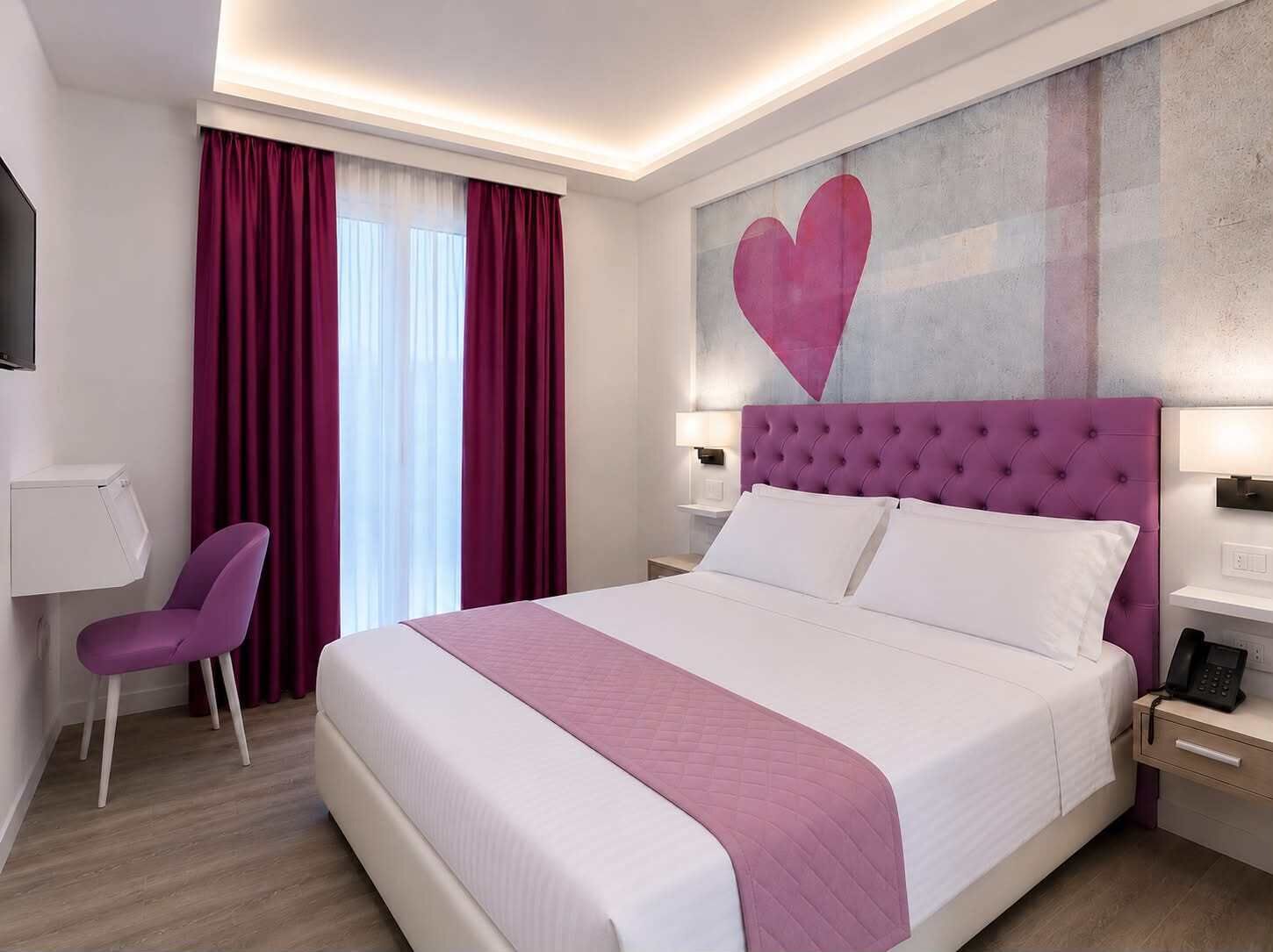 Ein Hotelzimmer mit Bett, Schreibtisch, Stuhl und einem großen Wandbild.