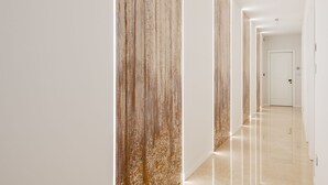 Un couloir moderne avec un sol brillant et des panneaux de bois verticaux.