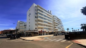 Un hôtel à plusieurs étages doté d’une cour intérieure, d’un passage piéton et d’un espace de stationnement.