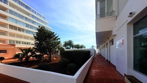 A corridor with a white wall, a brick base, and a tiled floor. - Charming 1-bedroom apartment with pool & garden in Roses Santa-Margarita (Roses)