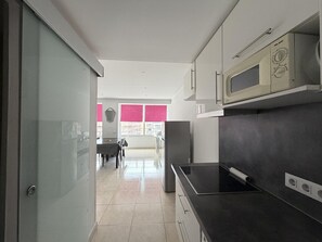 A modern kitchen with a black countertop, a microwave, and a stove.