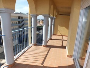 A balcony with a tiled floor, white columns, and a metal railing. - Apartment in Roses for 6 with pool and parking (Roses)